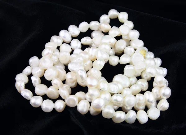 Perlas sobre un terciopelo negro — Foto de Stock