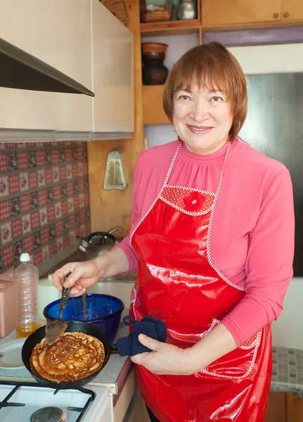 Mature woman cooking pancakes — Stock Photo, Image