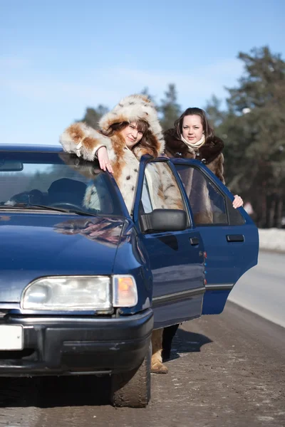 Two women with car in winter — Stock Photo, Image