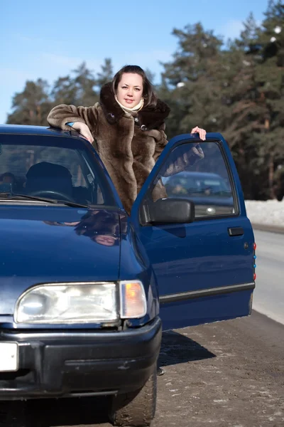 Mujer con su coche en invierno — Foto de Stock