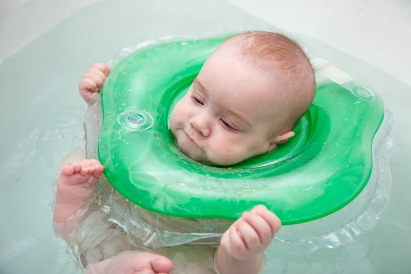 Baby swimming with neck swim ring — Stock Photo, Image