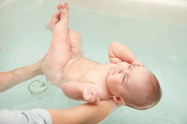 Bebê nadando nas mãos da mãe — Fotografia de Stock