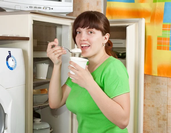 Woman eating dairy cream from fridge — Stock Photo, Image