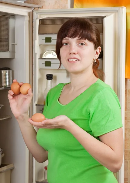 Frau legt frische Eier in Kühlschrank — Stockfoto