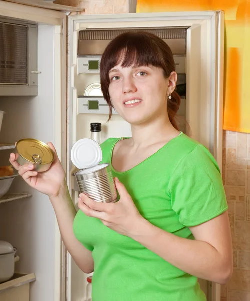 Donna mettendo con metallo può vicino frigorifero — Foto Stock