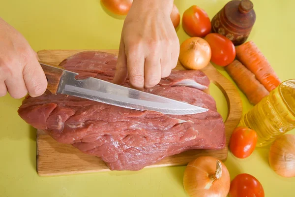 Руки повара режут мясо — стоковое фото