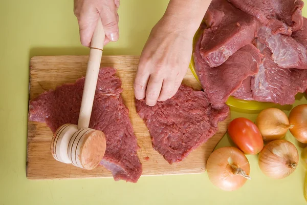Руки, делающие мясной пирог с молотком — стоковое фото