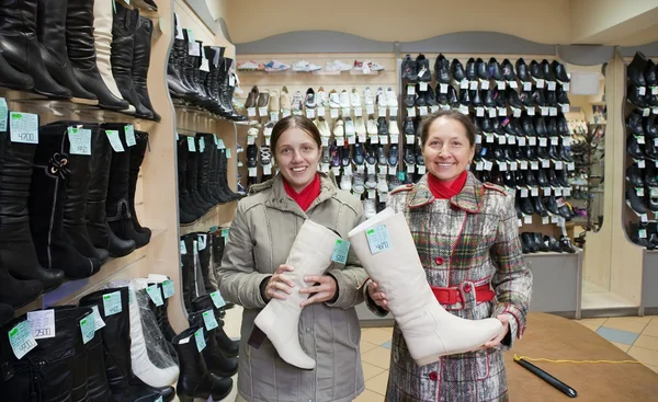 Vrouwen kiest laarzen bij schoenen shop — Stockfoto