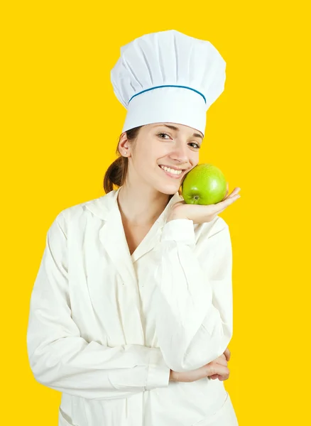 Girl in chef uniform holding apple — Stock Photo, Image