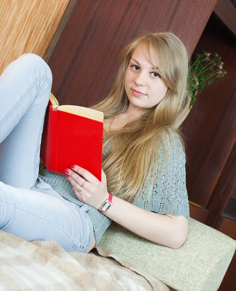 Meisje leesboek op sofa — Stockfoto
