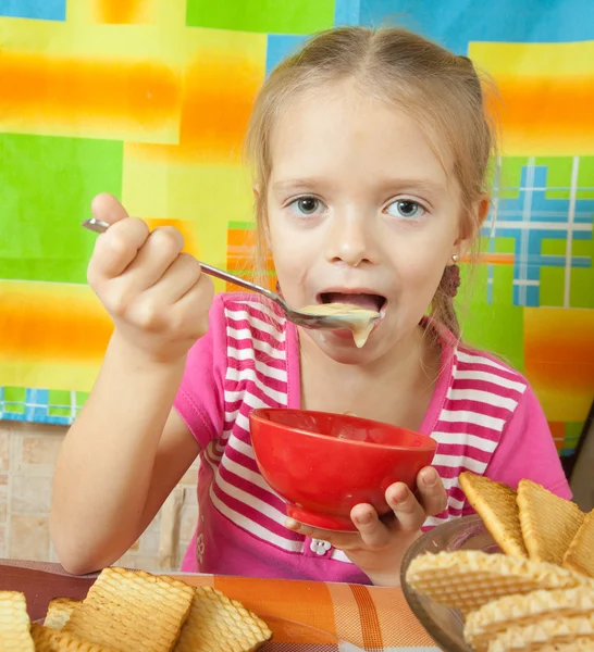 Menina comendo sobremesa de leite — Fotografia de Stock