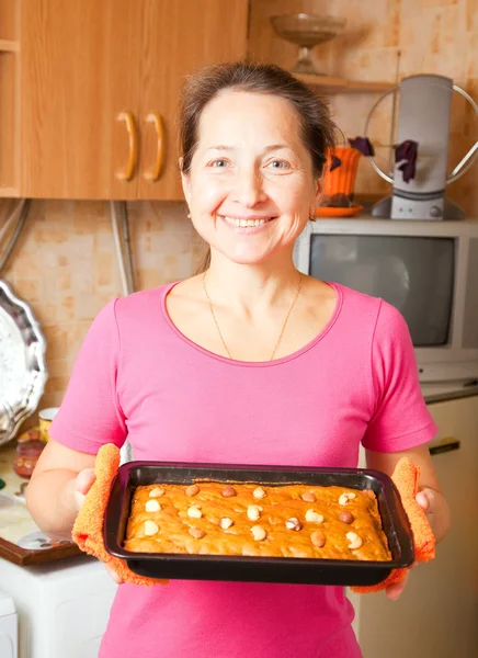 Ώριμη γυναίκα με φρέσκο μέλι κέικ — Φωτογραφία Αρχείου
