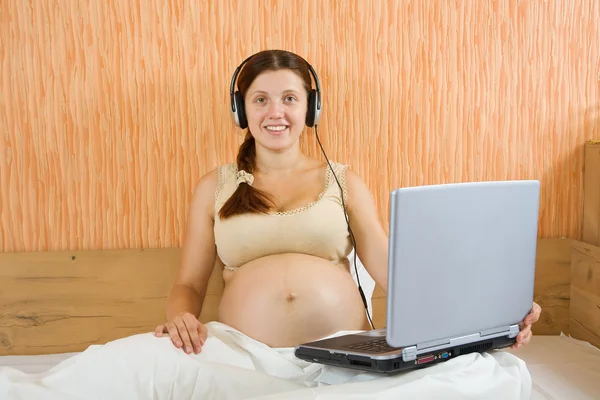 Těhotná žena poslechu hudby — Stock fotografie