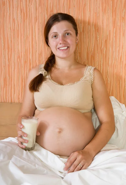 ミルクのガラスと妊娠中の女性 — ストック写真