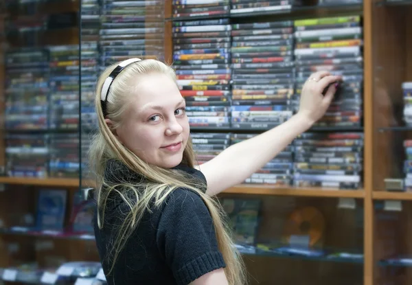 お店の女の子がディスクを選択します。 — ストック写真