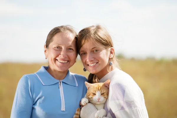 Мама с подростком держит кота. — стоковое фото