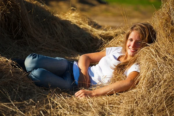 Menina descansando em feno fresco — Fotografia de Stock