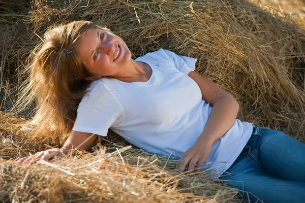 Girl enjoying on fresh straw — Stock Photo, Image