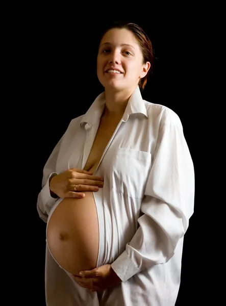 妊娠中の女性の腹、黒の背景を保持 — ストック写真