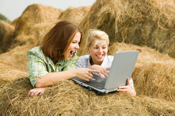 Glada tjejer med laptop — Stockfoto