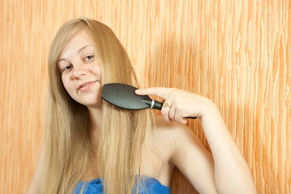 Menina penteando seu cabelo longo — Fotografia de Stock