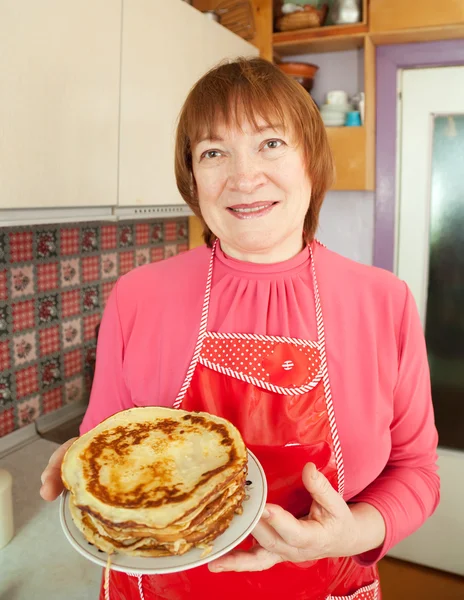 Kvinna med kokta pannkakor — Stockfoto