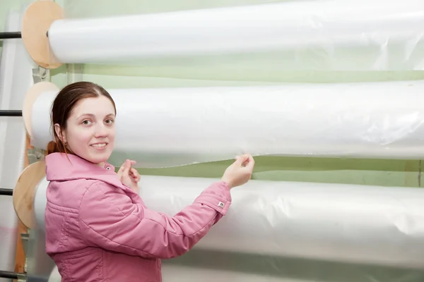 Mulher escolhe polietileno no rolo de papel alumínio — Fotografia de Stock