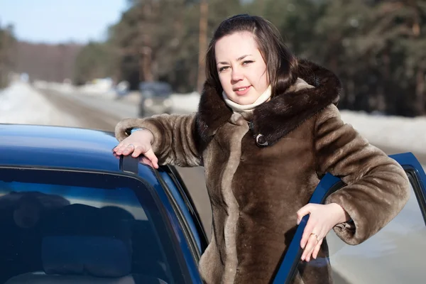 G mujer cerca de su coche en carretera de invierno — Foto de Stock