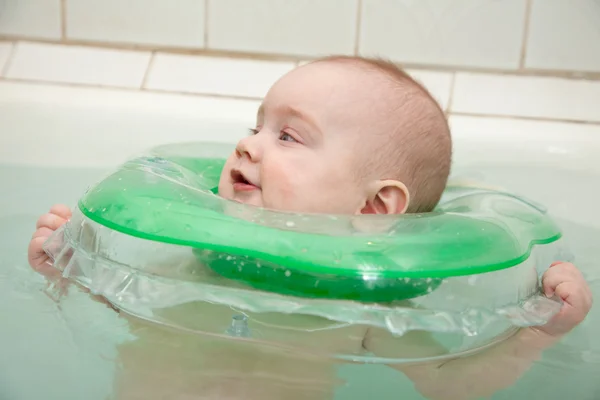 Natação do bebê com anel de natação no pescoço — Fotografia de Stock