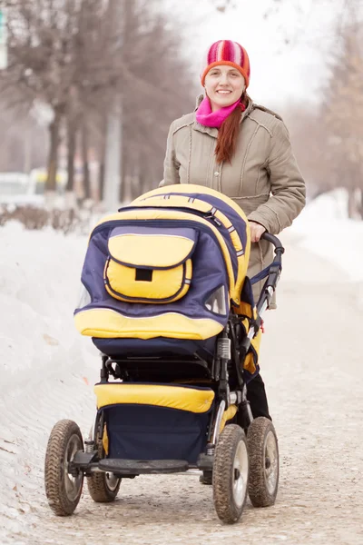 Kvinna med barnvagn i winte — Stockfoto
