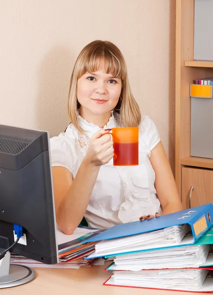 Kobieta z kubkiem herbaty w biurze — Zdjęcie stockowe