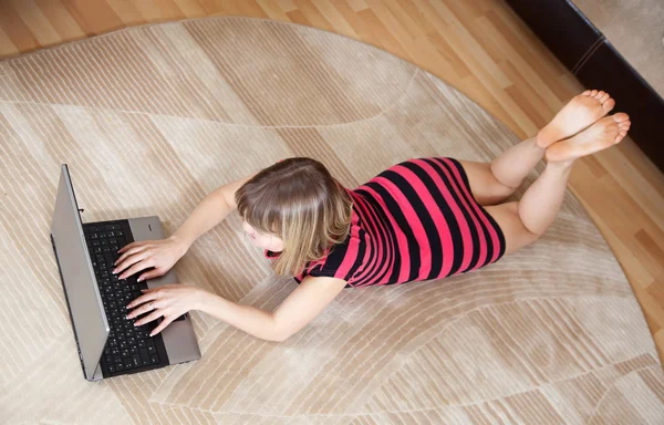 여 자가 바닥에 누워 노트북을 사용 하 여 — 스톡 사진