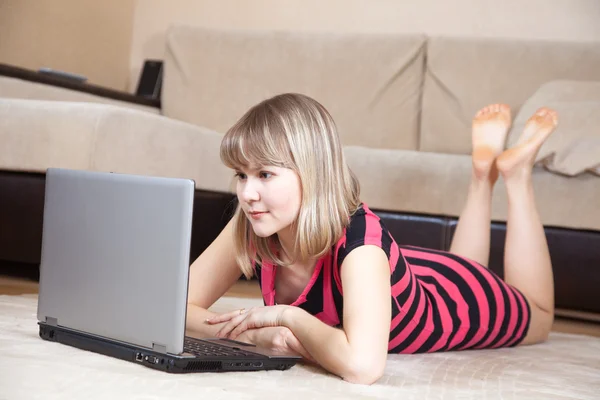 Dziewczyna leży na podłodze i przy użyciu laptopa — Zdjęcie stockowe