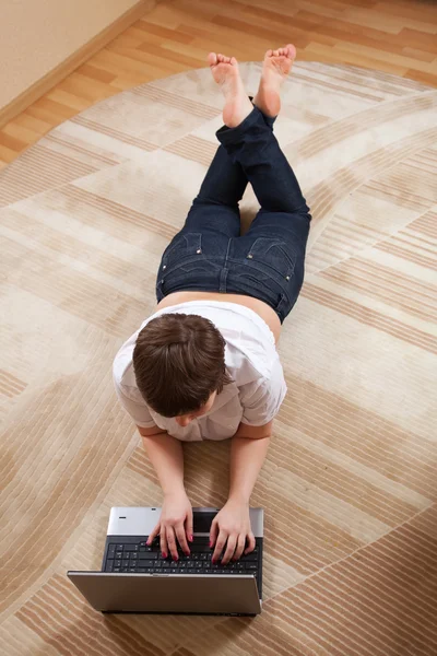 Kobieta, leżąc na podłodze i przy użyciu laptopa — Zdjęcie stockowe