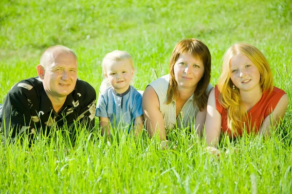 Familjen liggande på gräs — Stockfoto