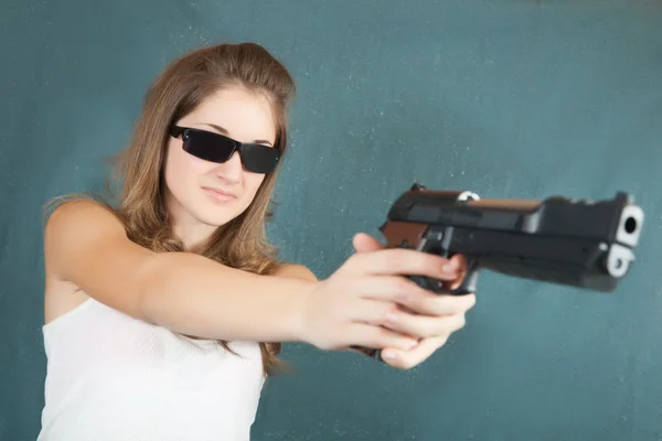 Flicka syftar en svart pistol — Stockfoto