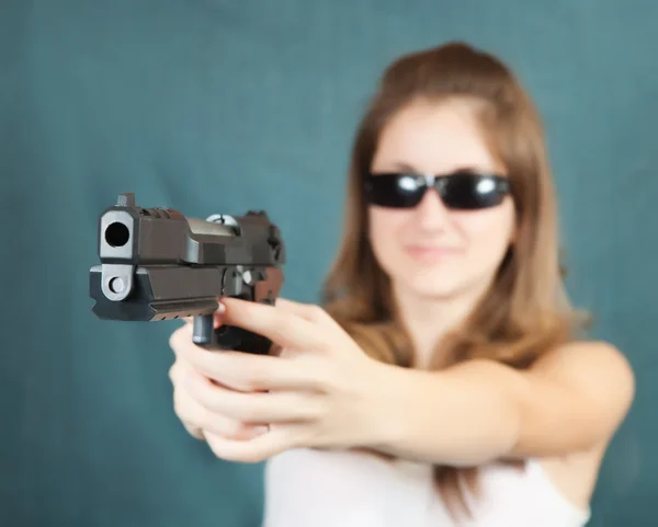 Chica apuntando un arma negra —  Fotos de Stock