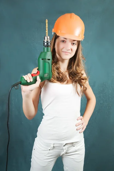 Female construction worker in a hard hat with drill — Stock Photo, Image
