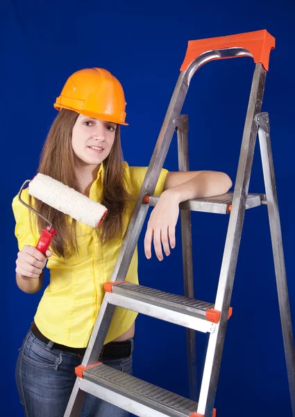 Chica en sombrero duro con rodillos de pintura —  Fotos de Stock