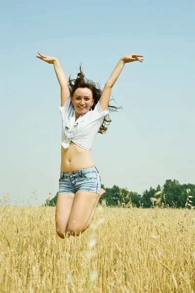 Meisje op het veld springen — Stockfoto