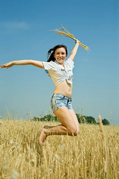 Menina de salto com orelhas de trigo — Fotografia de Stock