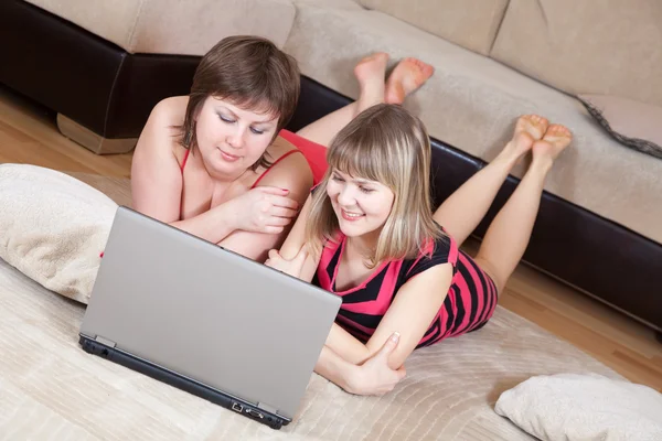 Chicas felices usando el ordenador portátil en casa —  Fotos de Stock