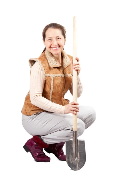 Happy mature woman sits with spade — Stock Photo, Image