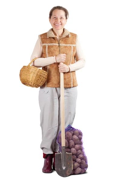 Happy woman with spade and potatoes — Stock Photo, Image