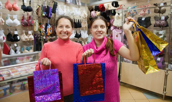 Mulheres com sacos de compras na loja de roupa interior — Fotografia de Stock