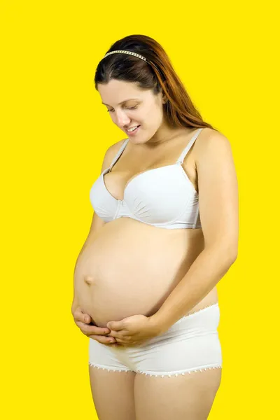 Беременная женщина, выглядящая брюхо — стоковое фото