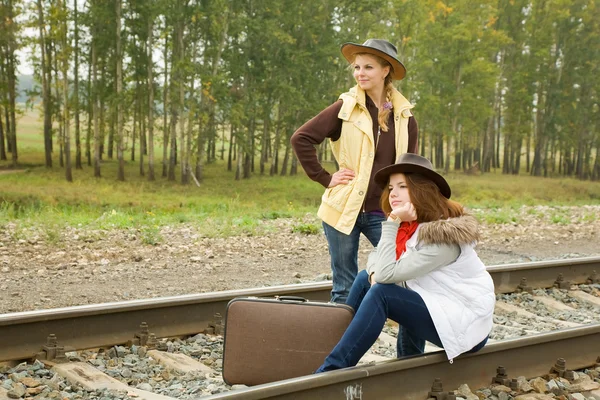 Flickorna sitter på järnväg — Stockfoto