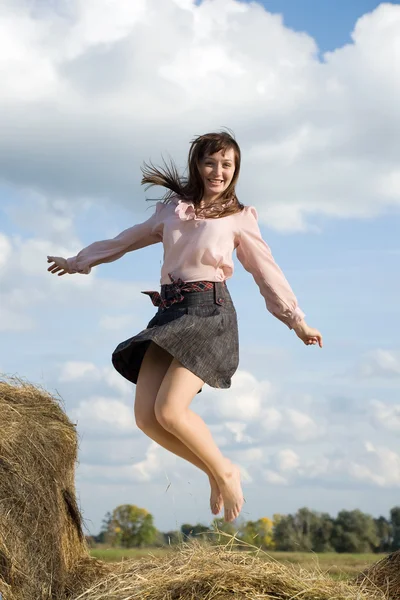 Saltando menina sobre feno — Fotografia de Stock