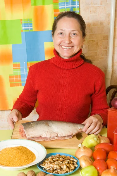 Donna sta cucinando pesce rosso — Foto Stock