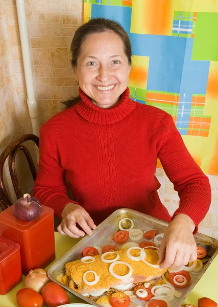 女性はパン粉魚を作る — ストック写真